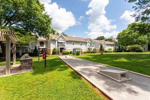 A sunny day at a residential area with houses and a well-maintained lawn.