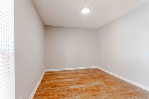 A room with wooden flooring and white walls.