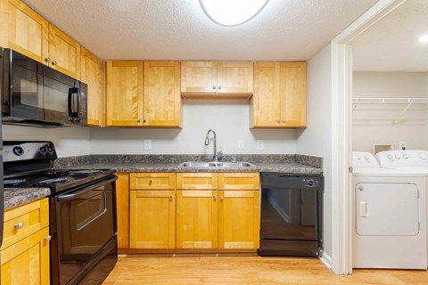 A kitchen with wooden cabinets and black appliances.