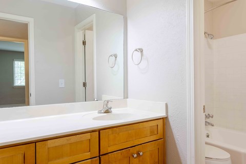 A bathroom with a white countertop and a white sink.