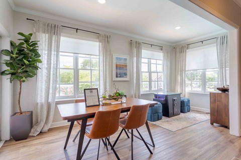 A dining room with a table and chairs.