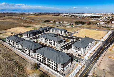 A large building complex with a parking lot in front.