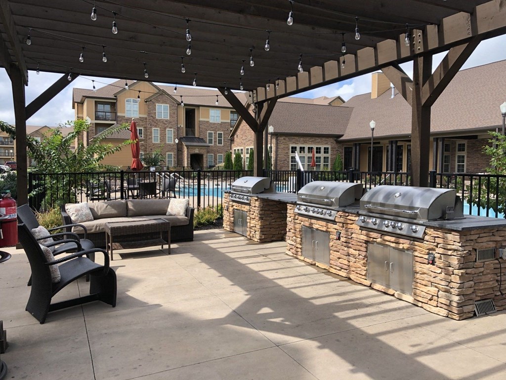 A patio with a grill and seating area.