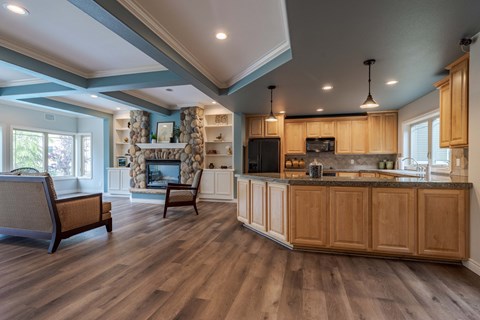 a kitchen and living room with a fireplace and wooden cabinets