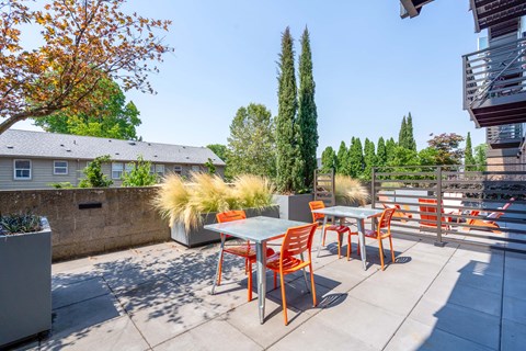 a seating area with tables and chairs on a patio