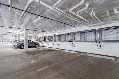 the parking garage of a building with cars parked in it
