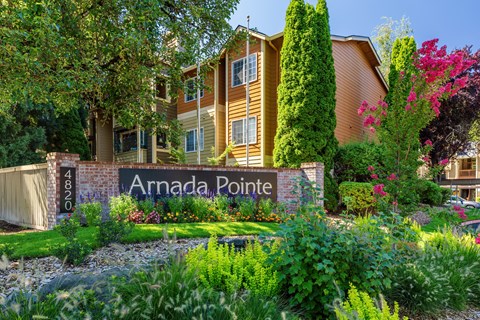 A sign that says "Arnada Pointe" in front of a building.