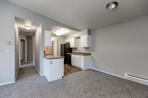 A spacious kitchen with white cabinets and black appliances