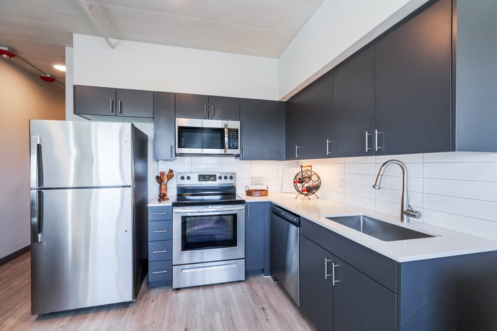 a kitchen with stainless steel appliances and black cabinets