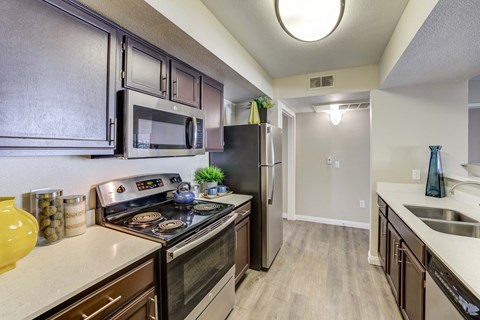 redesigned kitchen with stainless steel appliances and white counter tops and a stainless steel refrigerator
