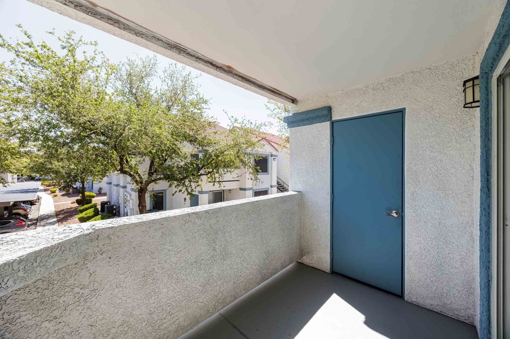 A blue door is on the right side of a white wall.