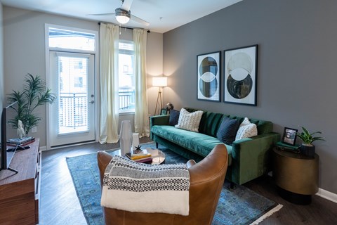 A living room with a green couch and a brown chair.