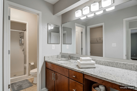 A bathroom with a marble countertop and a walk-in shower.