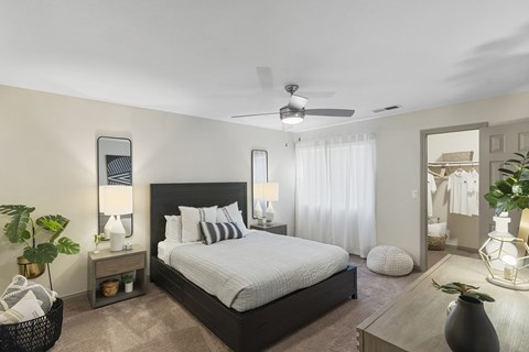 A bedroom with a large bed and a ceiling fan.