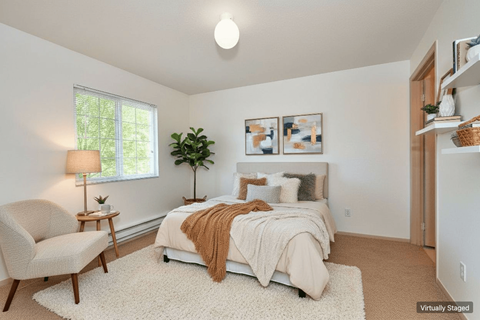 A bedroom with a bed, chair, and lamp.
