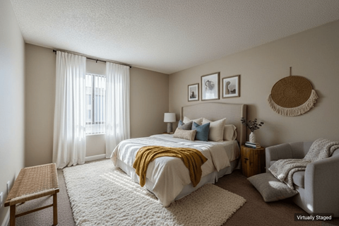 A bedroom with a bed, chair, and pictures on the wall.