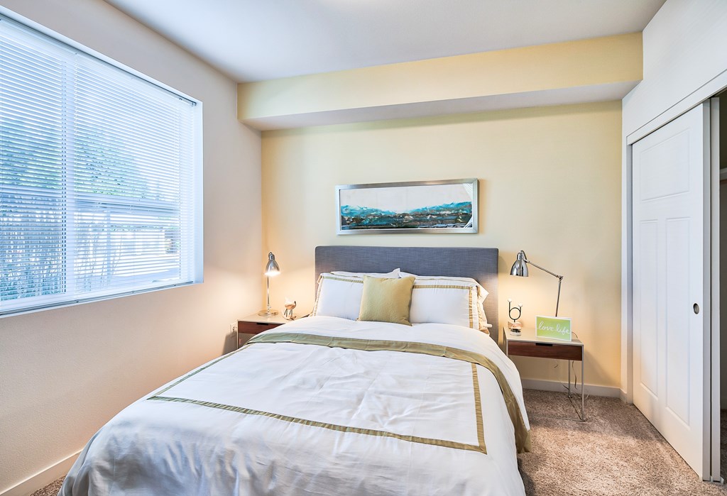 A bedroom with a large bed and a painting on the wall.