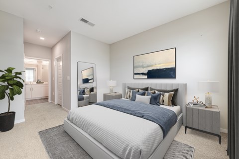 A bedroom with a large bed and a painting on the wall.