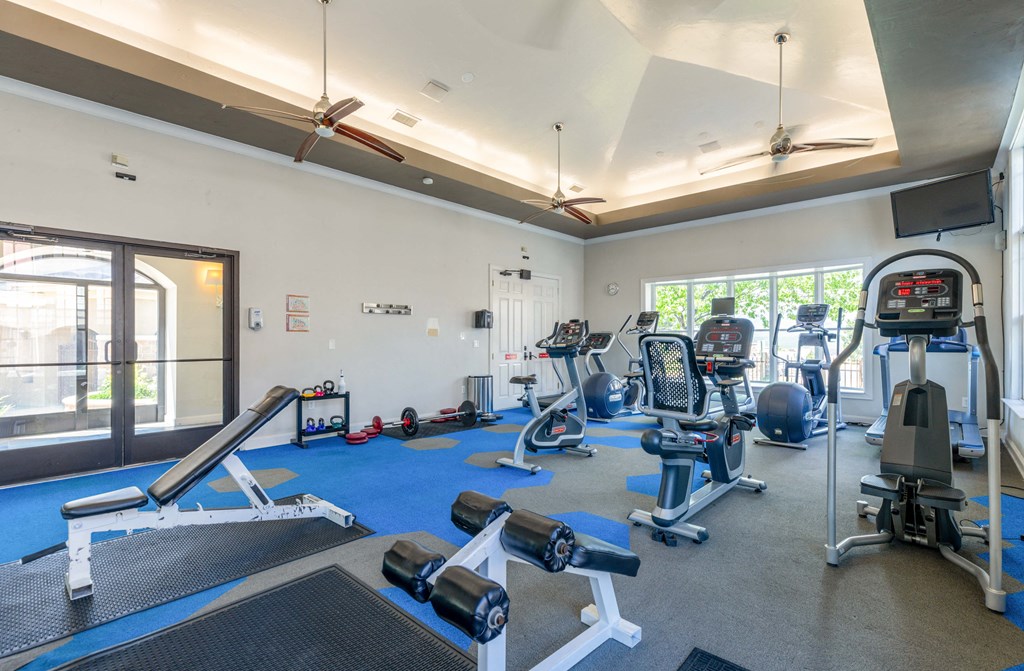 a gym with cardio equipment and weights at the belgard apartments