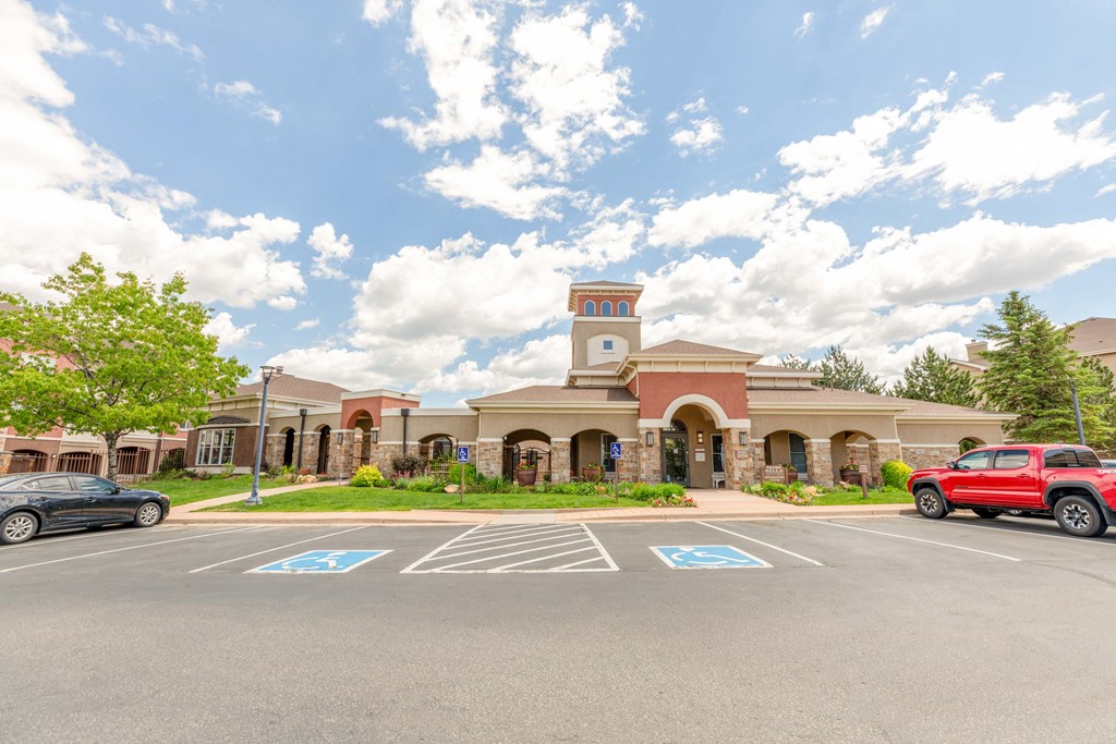 a parking lot in front of a building with cars parked in front