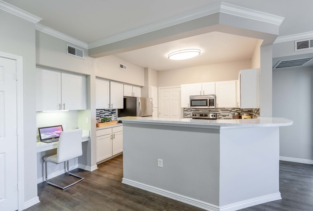 a kitchen with white cabinets and a large island with a counter top