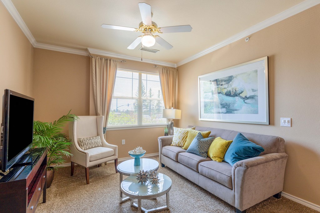 a living room with a couch and a ceiling fan