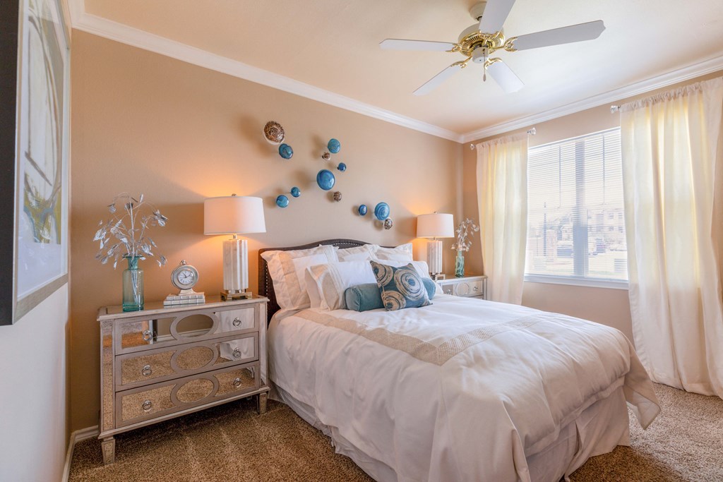 a bedroom with a bed and a dresser and a ceiling fan