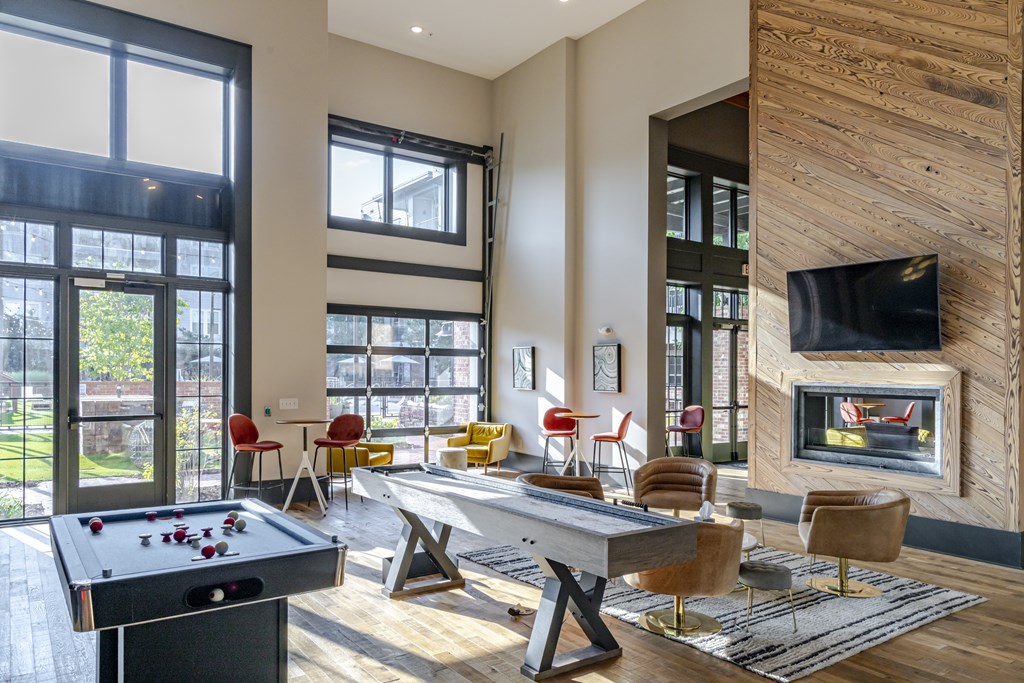 A clubroom with a pool table and a fireplace.