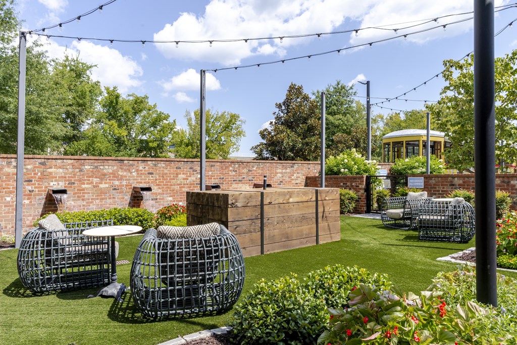 A patio with a table and chairs and a wall.