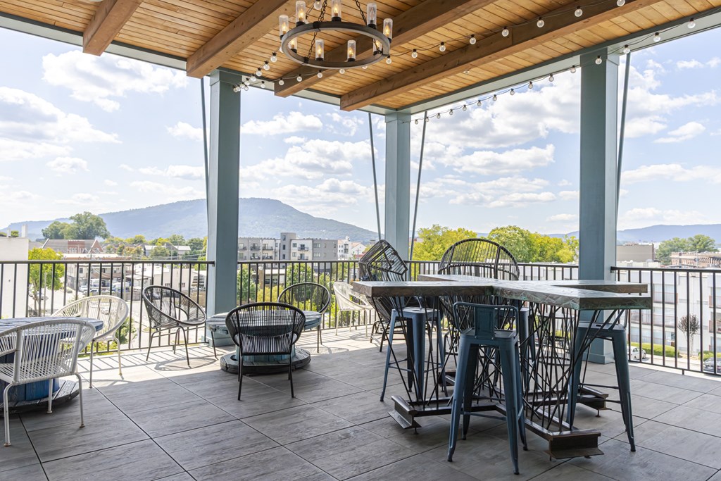 Rooftop sky lounge with table and chairs overlooking the mountains