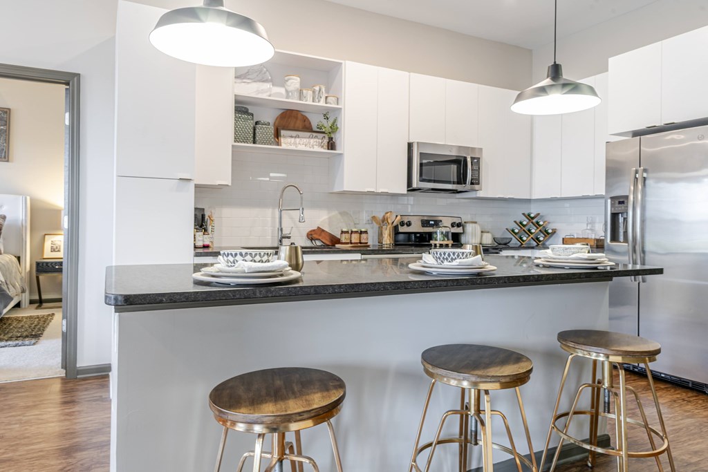 A kitchen with a bar stool and a counter.