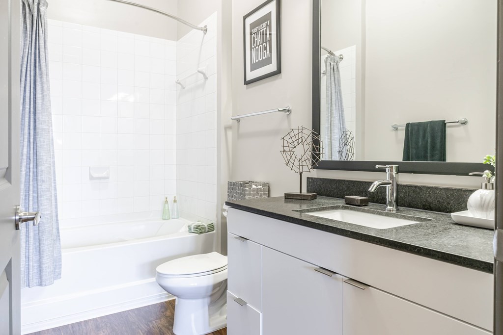 A white toilet sits next to a bathtub in a bathroom.