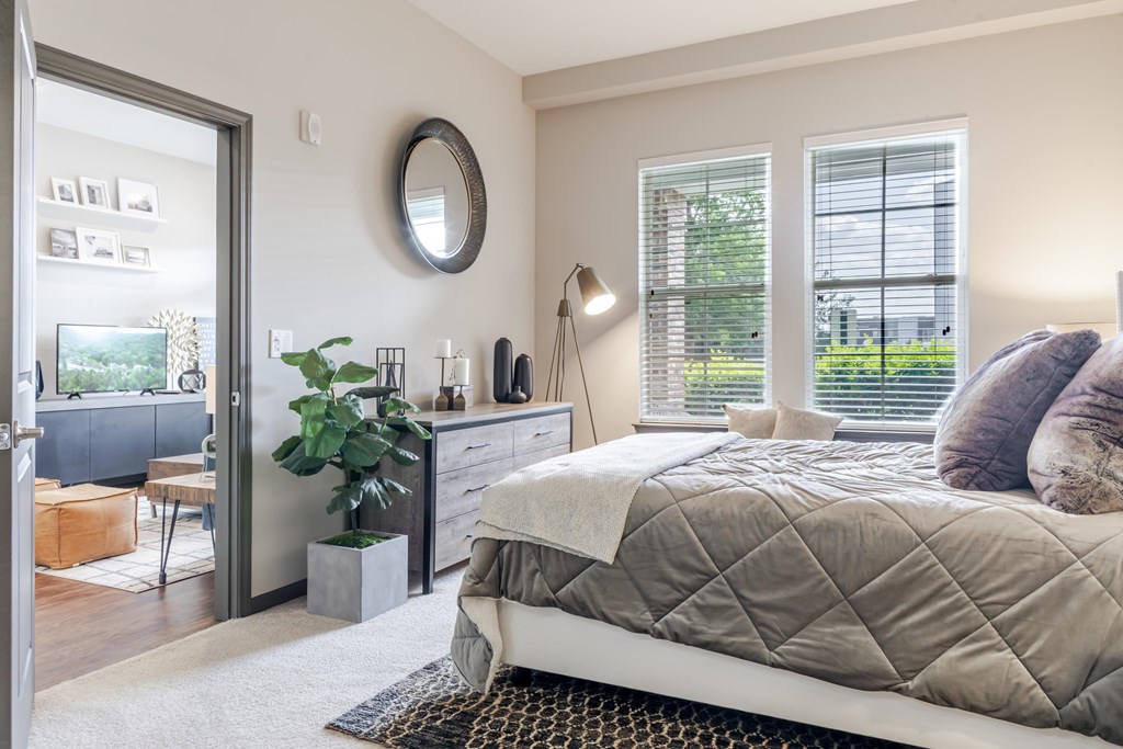 A bedroom with a large bed and a mirror on the wall.
