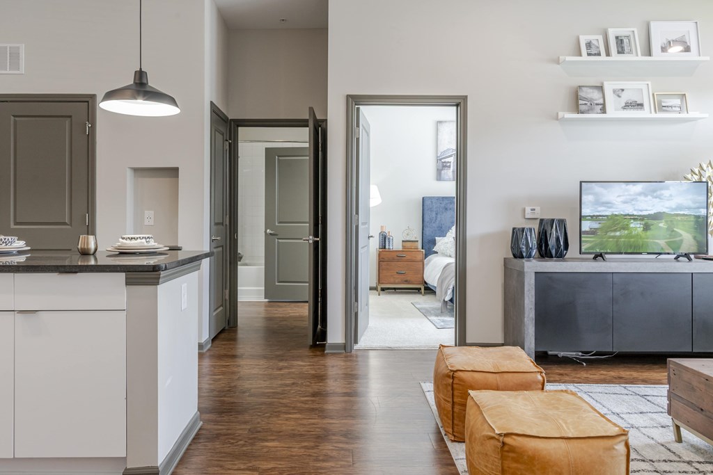 A modern kitchen with white cabinets and a wooden floor.
