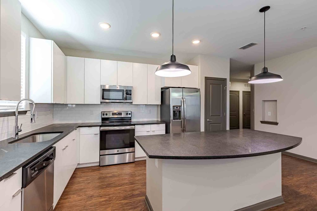A modern kitchen with a large island and stainless steel appliances.