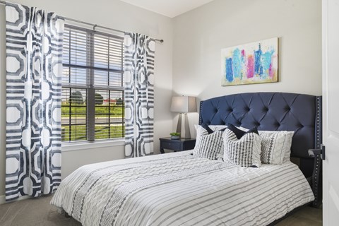 A bedroom with a large bed and a painting on the wall.