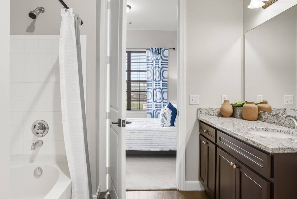 A bathroom with a white tub and a white shower curtain.