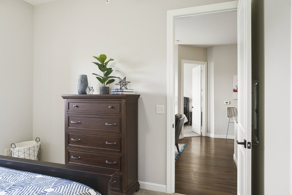 A bedroom with a bed, a dresser, and a mirror.