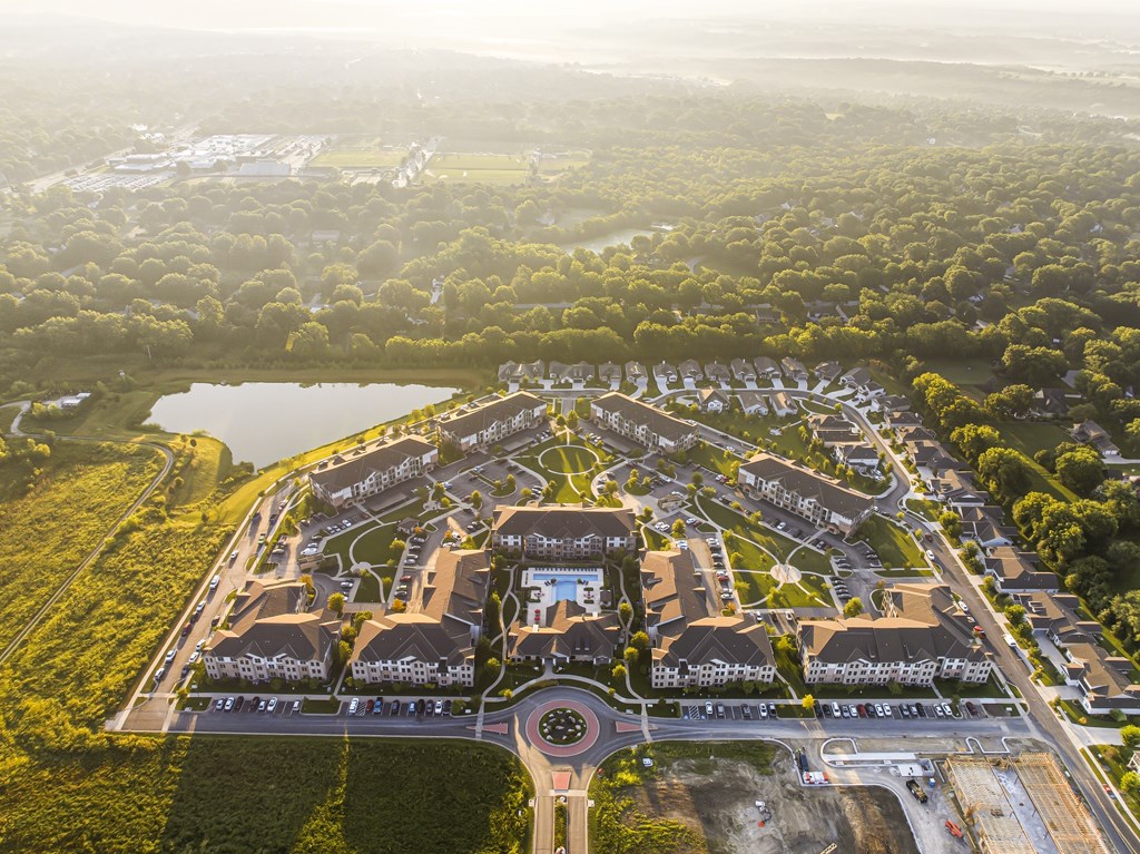 A bird's eye view of a residential area with houses and a lake.