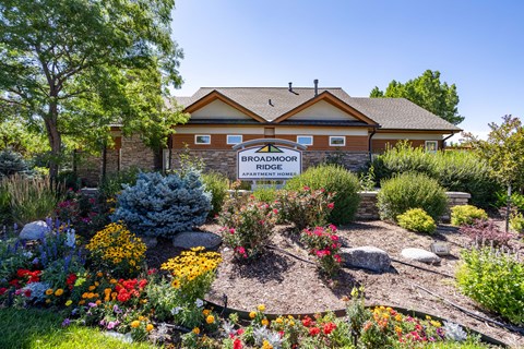 the front of a building with a flower garden in front of it