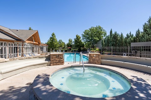 a round pool with a fence around it and a building in the background