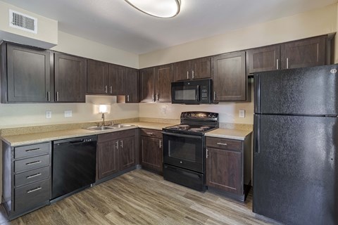 a kitchen with black appliances and dark wood cabinets