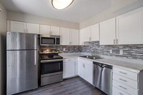 a kitchen with stainless steel appliances and white cabinets