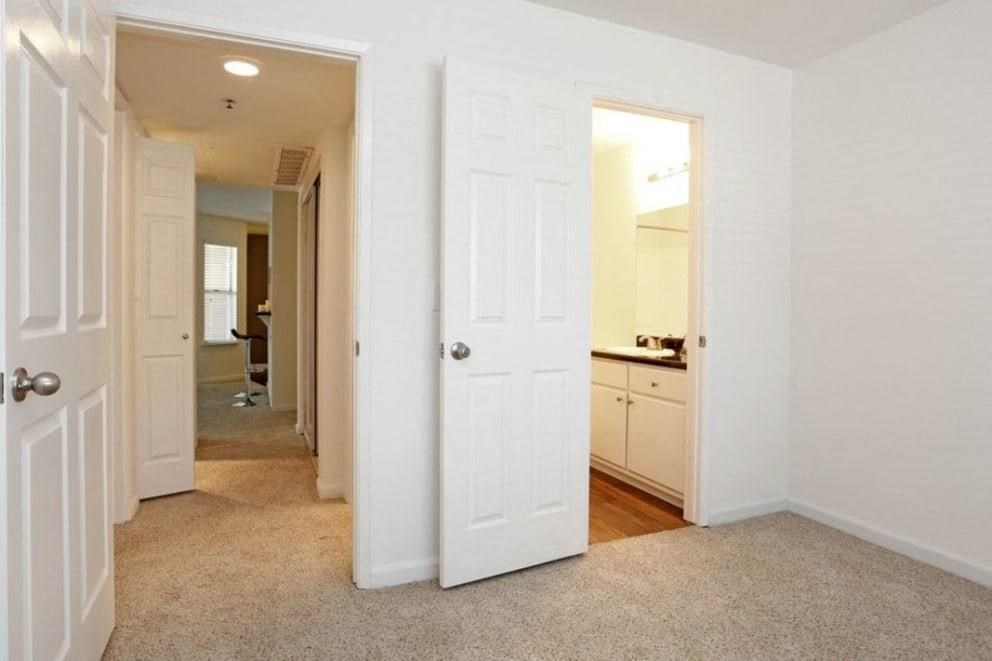 an empty bedroom with a door open to a hallway
