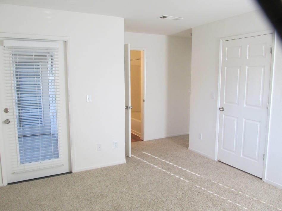 an empty living room with a door to a closet