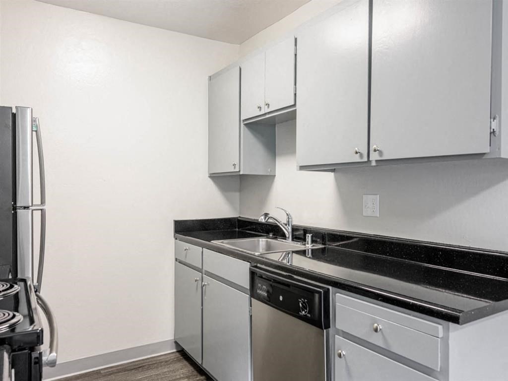 a kitchen with white cabinets and a sink and a refrigerator