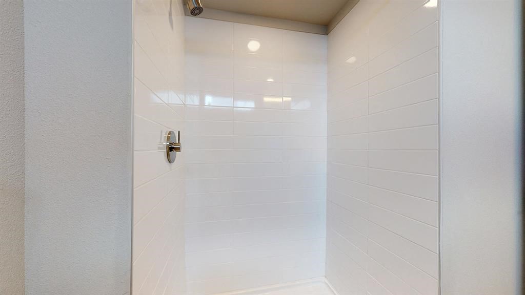 a white shower stall with a glass door