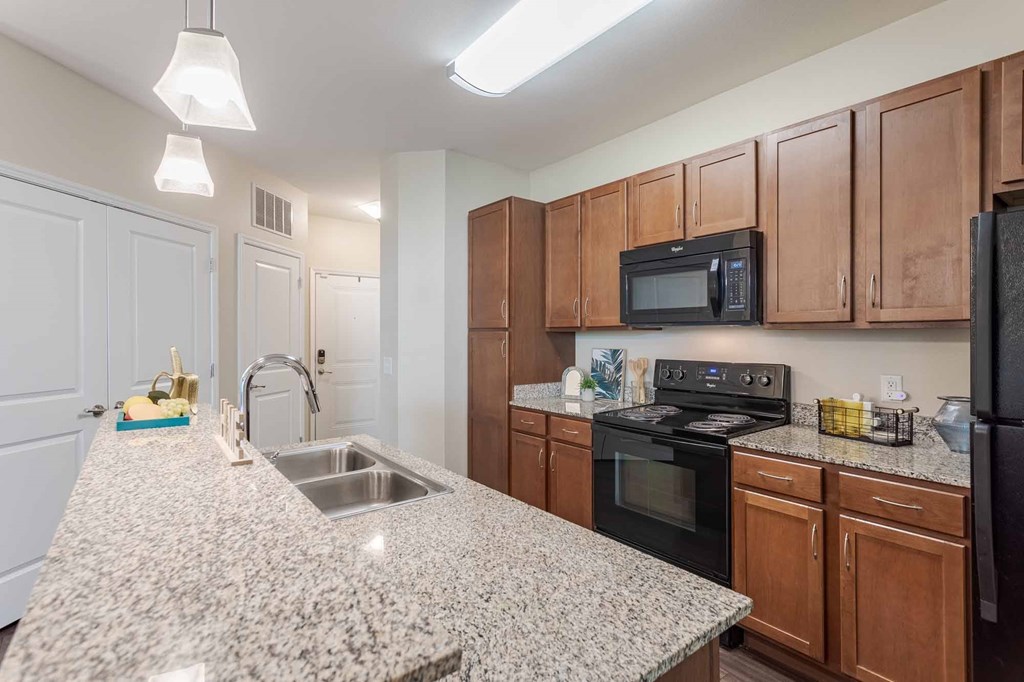 A kitchen with granite countertops and wooden cabinets.