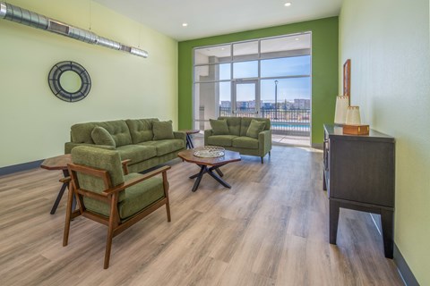 A living room with a green couch and a wooden coffee table.