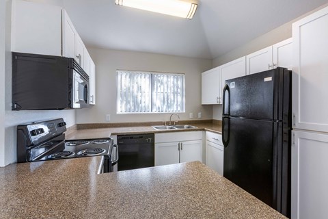 a kitchen with granite counter tops and black appliances
